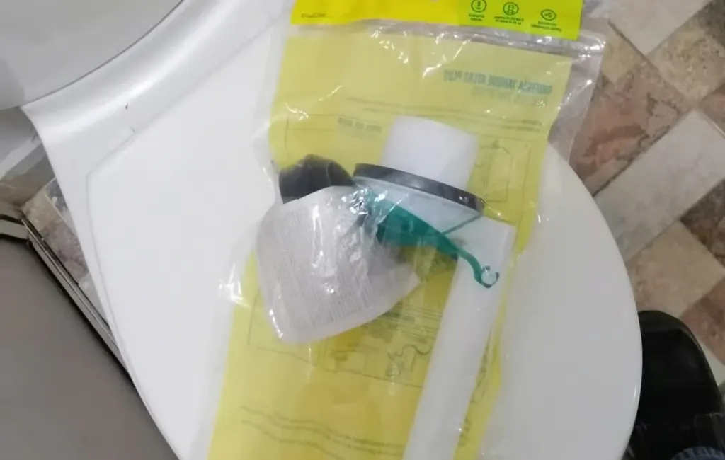 Válvula de llenado nueva, todavía en su empaque, sobre el sanitario que se va a reparar